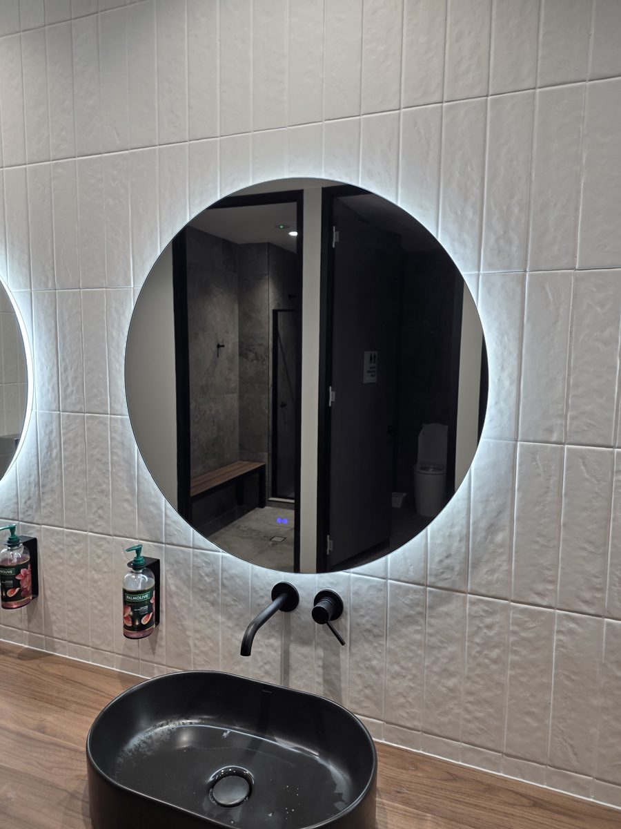 Amenities with round back-lit mirror and black basin